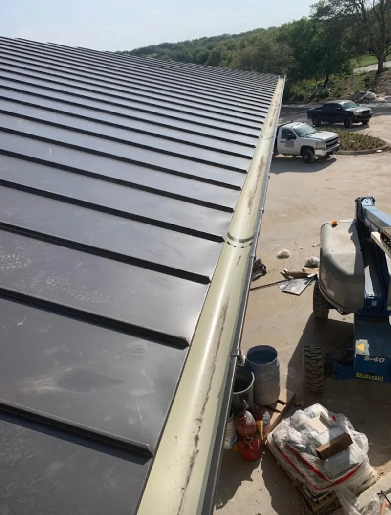 Standing seam panel and gutter detail on a metal roofing jobsite in Park Hills